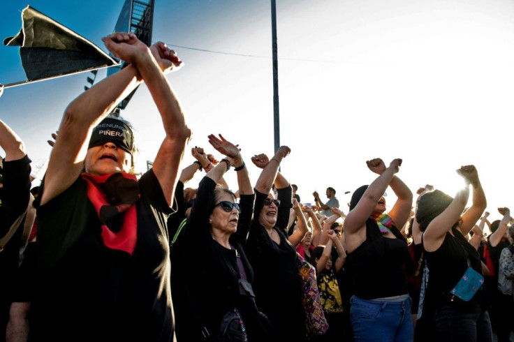 Women take part in a choreographed performance against gender violence outside Chile's national stadium in Santiago