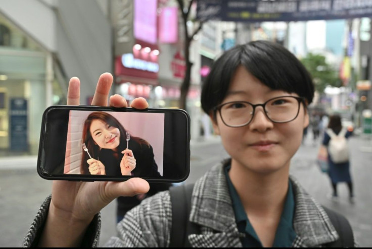 South Korean woman Yoon Ji-hye displaying an old photo of herself, before she embraced a feminist movement that shuns traditional patriarchal expectations