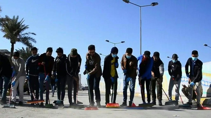 Iraqi volunteers clean up the streets of the central city of Najaf following anti-government protests. The protest movement is Iraq's biggest since the US-led invasion of 2003 toppled Saddam Hussein and installed a democratic system in the oil-rich but po