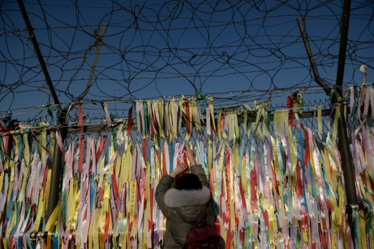 A woman hangs a 'peace ribbon' on a fence at the Imjingak 'peace park' near the Demilitarized Zone (DMZ) separating the two Koreas -- South Korean President Moon Jae-in spoke with US leader Donald Trump after the North's latest weapons test