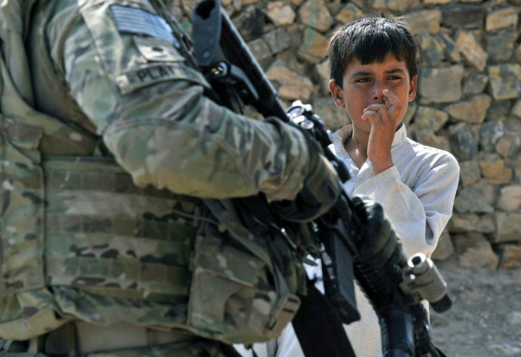 An Afghan youth looks at a US soldier in Nangarhar province of Afghanistan in 2011
