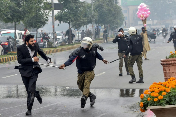 A policeman chases a lawyer following the clash at a Lahore cardiac hospital