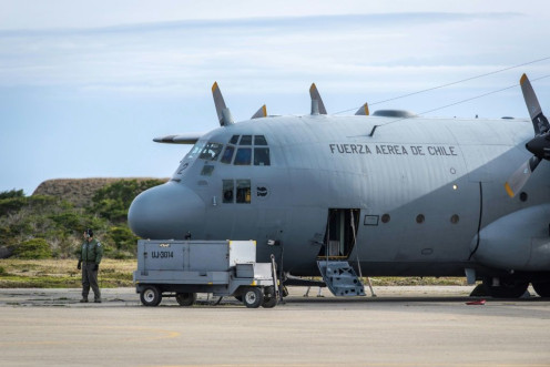 A man stands next to a C-130 plane that returned to Punta Arenas, Chile, from a search of the Drake Passage for a missing Air Force plane with 38 people aboard