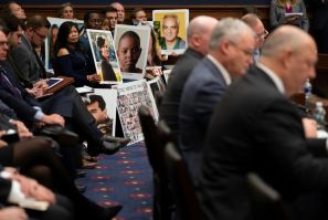 People hold up pictures of the victims of Boeing 737 MAX accidents as Federal Aviation Administration Administrator(FAA) Stephen Dickson(R) testifies before the House Committee on Transportation and Infrastructure on Capitol Hill