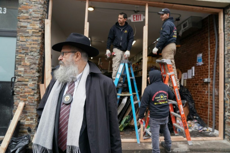 Demolition and recovery crews work at the scene of a shooting at a Jewish deli, which left four bystanders and two shooters dead