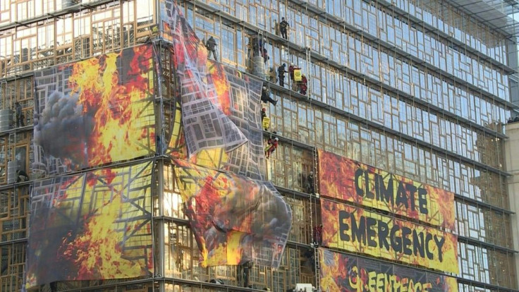 Greenpeace activists deploy a banner on the faÃ§ade of the European Council building in Brussels after scaling it