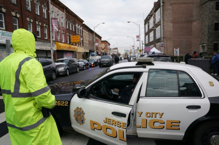 Police gather evidence a day after a deadly shooting at a Jewish deli in the New York suburb of Jersey City