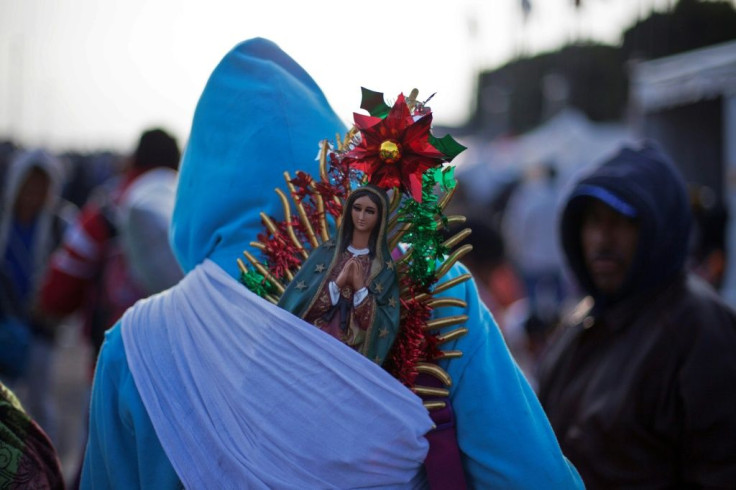 A pilgrim totes a statue of the Virgin of Guadalupe -- Mexico's City's patroness -- on his back