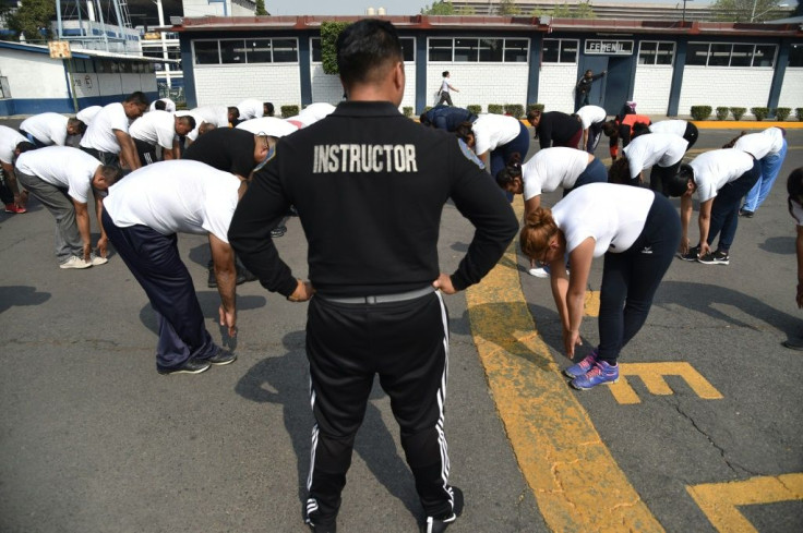 Physical trainer Javier Ramirez (C) works with police officers at a police unit in Mexico City