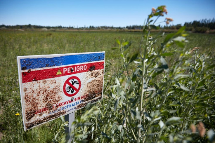 A sign reads "Warning" near a closed gas well after a spill in Allen, Rio Negro province, Argentina