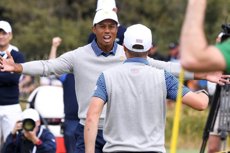 Tiger Woods (L) and Justin Thomas celebrate winning their match on day two