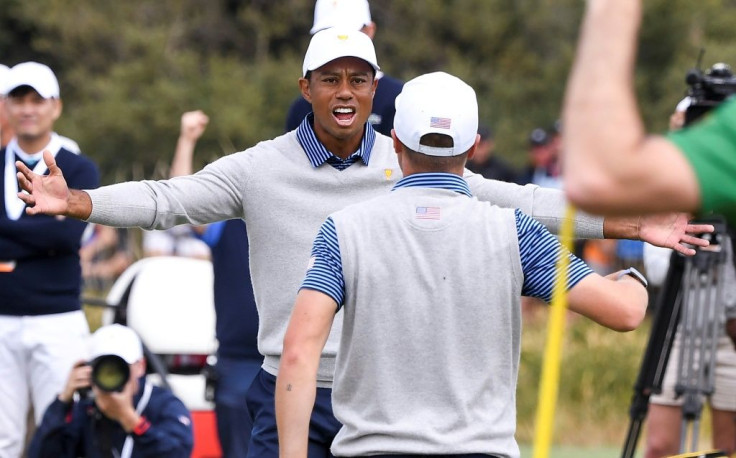 Tiger Woods (L) and Justin Thomas celebrate winning their match on day two