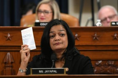 Democratic lawmaker Pramila Jayapal holds up a copy of the Constitution as she votes to impeach President Donald Trump