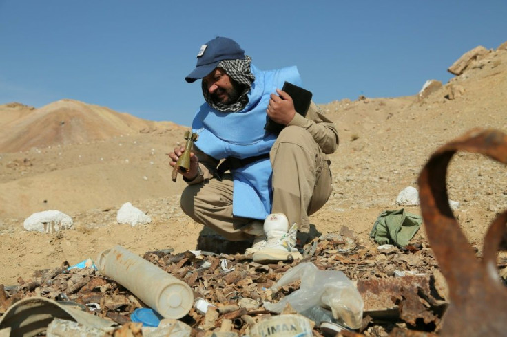 An Afghan deminer working for the Danish Demining Group holds a mortar bomb dating back to the Soviet invasion