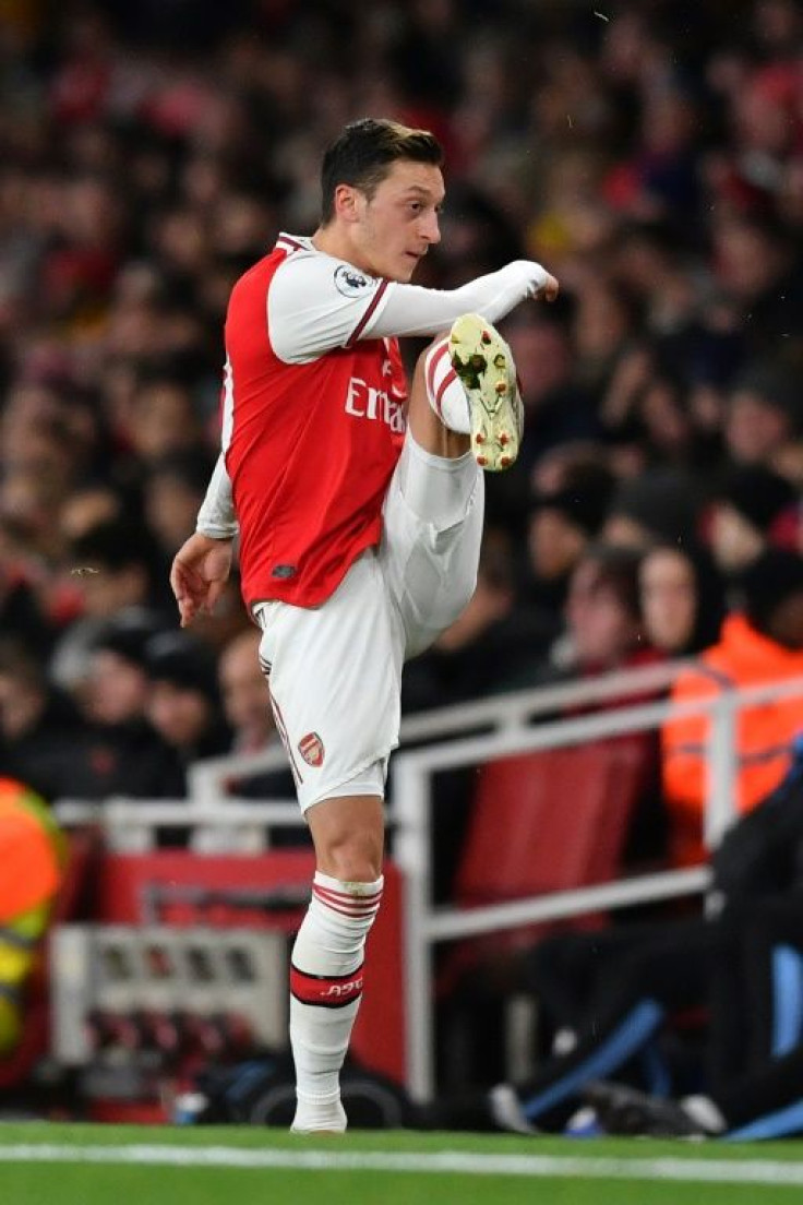 Mesut Ozil reacts to his substitution in Sunday's 3-0 defeat to Manchester City by kicking his gloves away