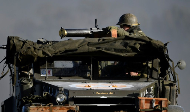 Actors wearing WWII US uniforms drive an armoured vehicle as they take part in a re-enactment of the Battle of the Bulge as part of commemorations marking the 75th anniversary