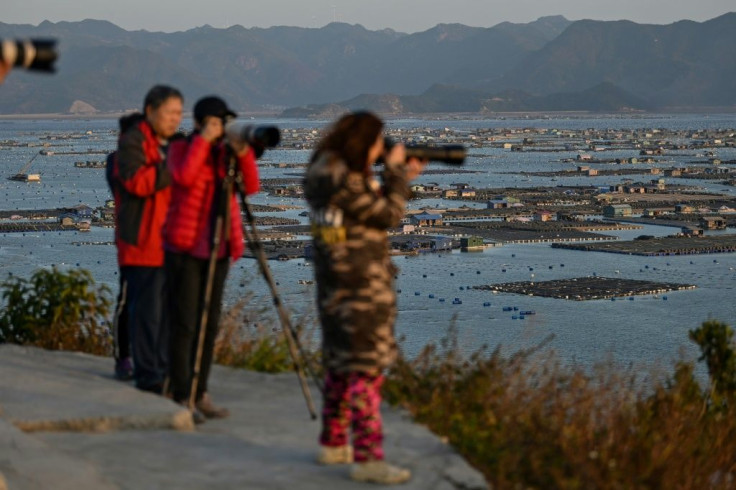 Chinese tourists take photos of the coastal flats from Dong An Island in Xiapu, Fujian province. The area is a major draw for photographers