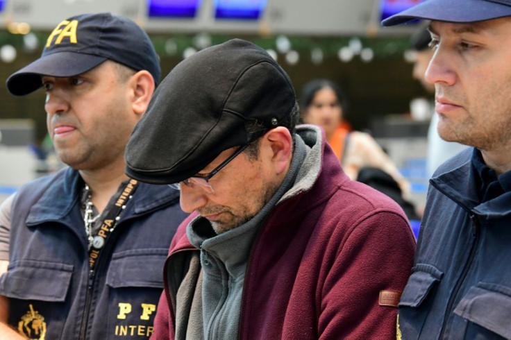 A handcuffed Mario Sandoval (C) escorted by police after his arrival in Buenos Aries