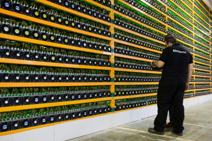 In this file photo taken on March 19, 2018 two technicians inspect bitcoin mining at Bitfarms in Saint Hyacinthe, Quebec