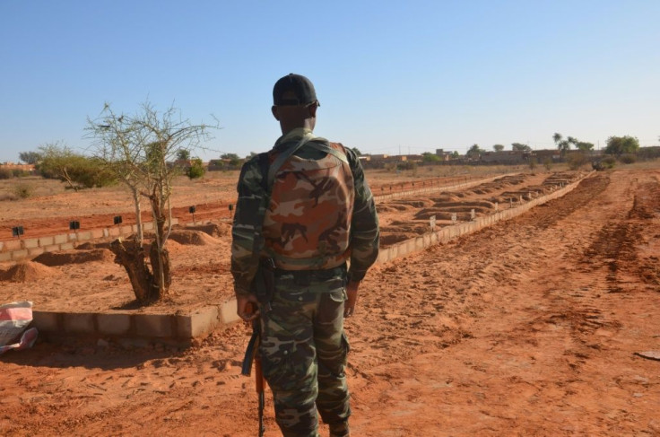 A Nigerien soldier looks at the graves of military personnel killed in a jihadist attack ahead of the arrival of G5 Sahel leaders on December 15, 2019