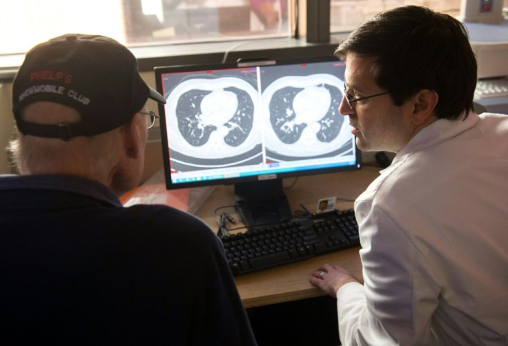 Dr. Christian Hinrichs (R), an investigator at the National Cancer Institute in immunotherapy for HPV+ cancers, shows a survivor of metastatic cancer the difference between his CT scan showing cancerous tumors and a clean scan after treatment