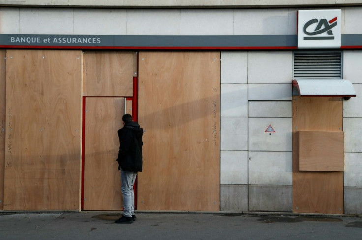 Banks and retailers boarded up windows along the march route in Paris on Tuesday, after vandalism marred previous protests.