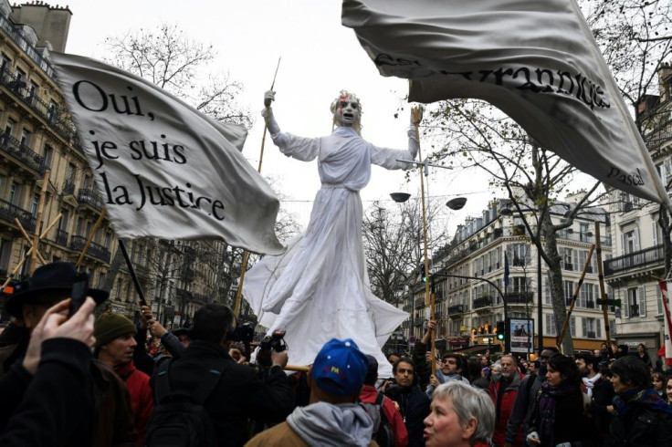 Paris protesters hold aloft a figure representing justice