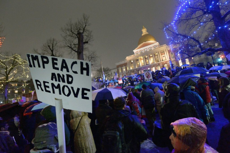 Protesters gather on Boston Common near the Massachusetts State House during a rally where over a thousand people stood in the rain and snow, calling for the impeachment of President Donald Trump