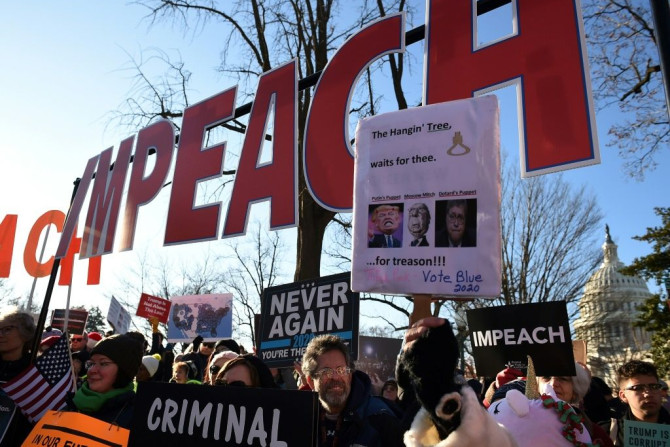 People rally in support of the impeachment of US President Donald Trump in front of the US Capitol, as the House of Representatives prepares for a landmark vote