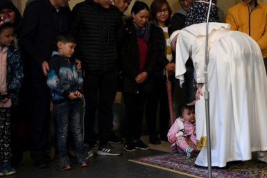 Pope Francis (R) blesses a toddler during an audience with refugees who arrived in Italy from the Greek island of Lesbos