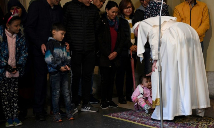 Pope Francis (R) blesses a toddler during an audience with refugees who arrived in Italy from the Greek island of Lesbos
