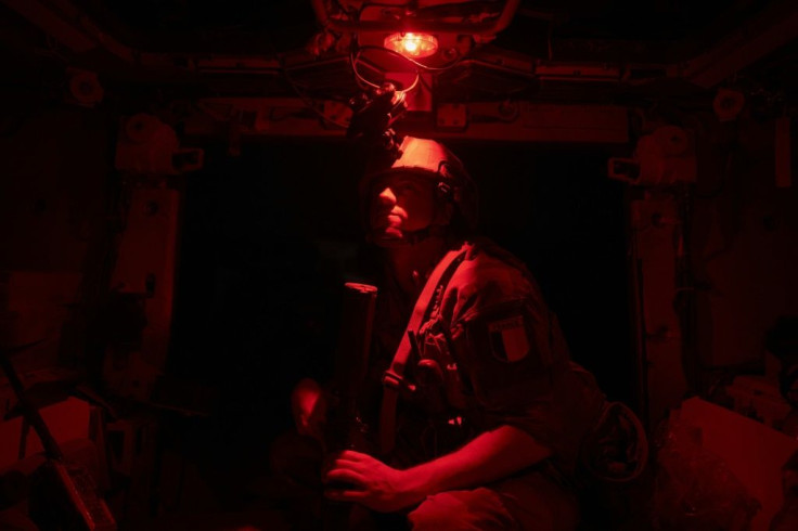 Night watch: A sergeant stands guard inside an armoured personnel carrier
