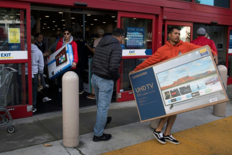Shoppers carry televisions purchased from a store during Black Friday sales in Los Angeles