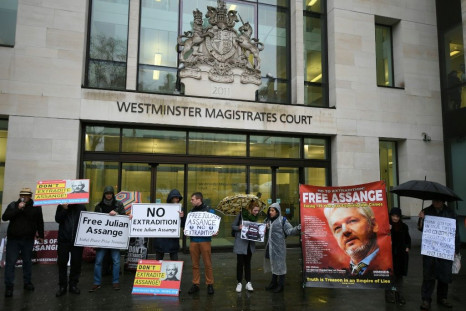 Supporters wave banners outside the London court where WikiLeaks founder Julian Assange was testifying about how he was spied on inside the Ecuadoran embassy