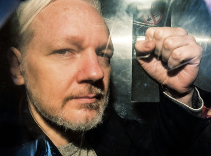 Assange gestures from the window of a prison van as he is driven into Southwark Crown Court in London on May 1