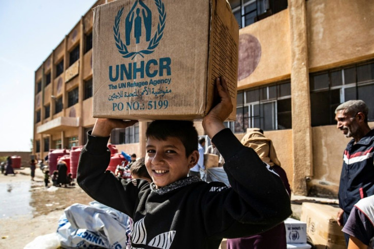 Displaced Syrians, who fled their homes in the border town of Ras al-Ain, receive humanitarian aid on October 12, 2019, in the town of Tal Tamr -- a UN resolution that would have extended aid for a year has been vetoed