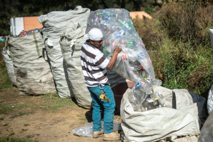 A Mexican worker loads bags with empty plastic bottles at a recycling center in Cheran