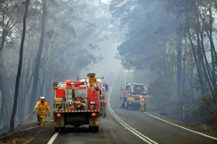 Crew have toiled in searing temperatures and thick acrid smoke as they try to curb a 'mega-blaze' that has turned a swathe of national park near Sydney to ash
