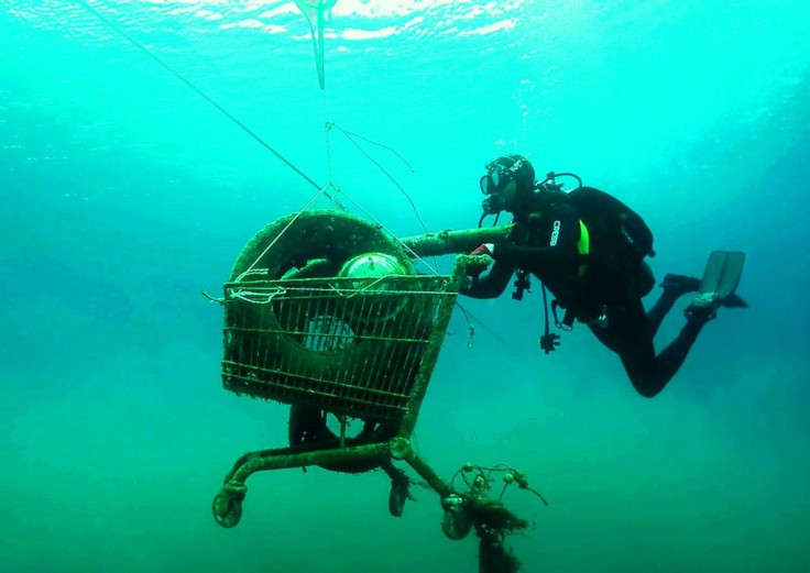 A volunteer for Greek environmental group Aegean Rebreath collects a trash-filled shopping cart from the sea on the Ionian island of Zakynthos