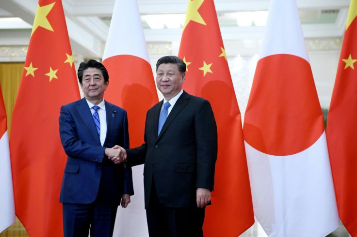 Japan's Prime Minister Shinzo Abe (left) shakes hand with China's President Xi Jinping at the Great Hall of the People in Beijing