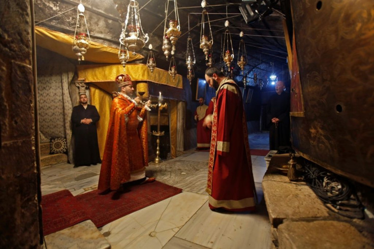 Priests pray in the Grotto of the Church of the Nativity in Bethlehem ahead of the midnight mass on Christmas Eve