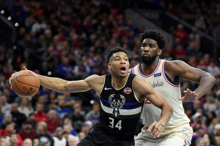 Milwaukee's Giannis Antetokounmpo looks to pass as Philadelphia's Joel Embiid defends in the 76ers' 212-109 NBA victory over the Bucks