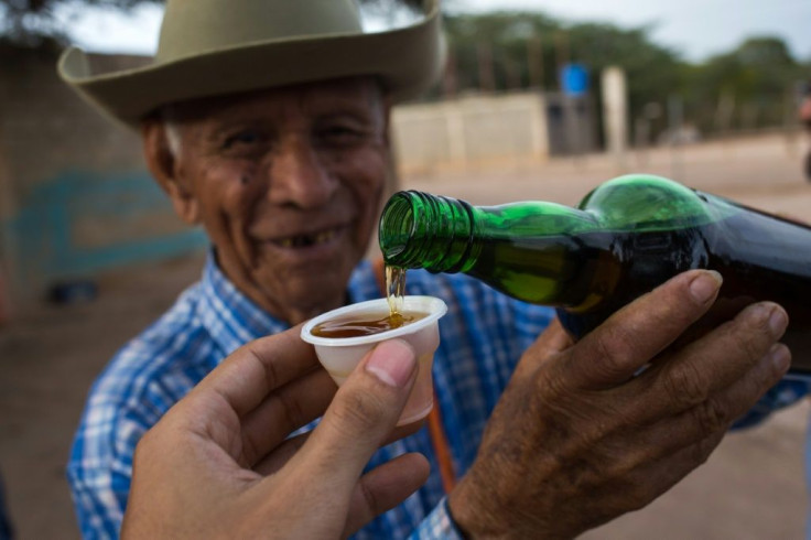 Venezuelan distiller Dolores Gimenez, 84, serves a cup of cocuy, a traditional liquor, at the Coari craft distillery in Bobare