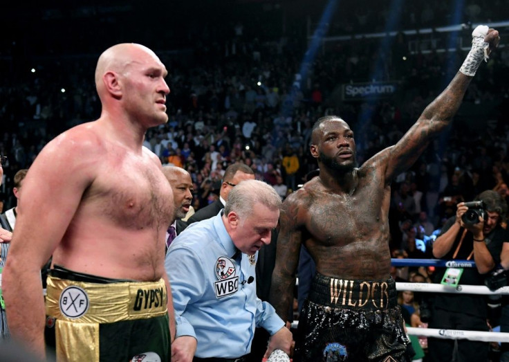 Tyson Fury and Deontay Wilder wait for a decision with referee Jack Reiss before a draw is announced in their WBC heavyweight world title fight in Los Angeles on December 1, 2018