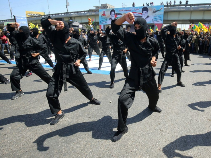 A picture taken on May 31, 2019 shows Iraqi Shiite fighters from the Iran-backed armed group, Hezbollah brigades take part in a military parade to mark the pro-Palestinian Al-Quds (Jerusalem) Day in Baghdad