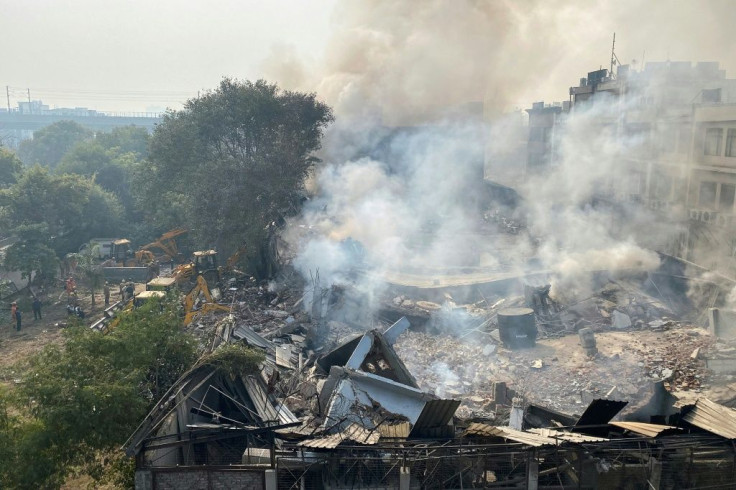 Smoke rises over the debris of a building that collapsed during a fire in New Delhi