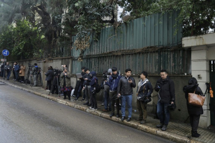 Journalists wait outside a Beirut house identified by court documents as belonging to Ghosn