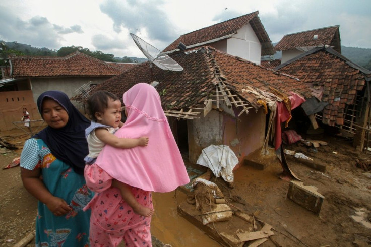 Villagers walk past homes damaged by flooding in Lebak, neighbouring Jakarta