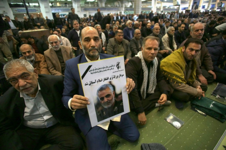 An Iranian man holds a poster of slain Iranian Revolutionary Guards Qasem Soleimani during a special prayer ceremony in Tehran to mourn the "martyr" killed in a US strike in Baghdad