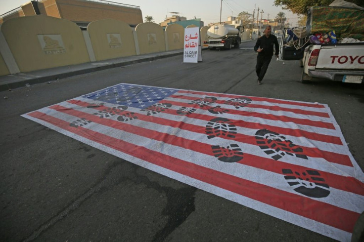 A mock US flag is laid on the ground for cars to drive over in the Iraqi capital Baghdad